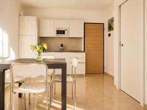 a kitchen with a table and chairs in a room at Apartment Mare45 - 10 minutes walk from the beach with one private ombrella and three sun-beds in Eraclea Mare