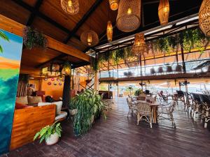 a restaurant with tables and chairs and plants at Shaan Coco Palms Beach Resort in Morjim