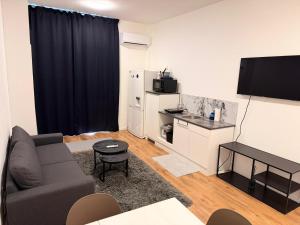 a living room with a couch and a kitchen with a refrigerator at Ejon in Lelystad