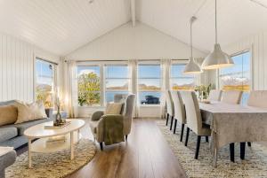 a dining room and living room with a table and chairs at Lofoten Oceanfront - Privat Pier & Beach in Vestvågøya