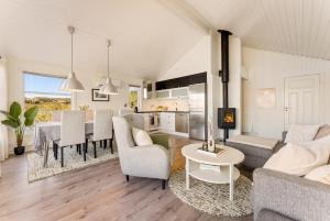 a living room and kitchen with a couch and a table at Lofoten Oceanfront - Privat Pier & Beach in Vestvågøya