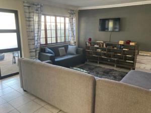 a living room with two couches and a tv at 51 on Parfitt in Bloemfontein