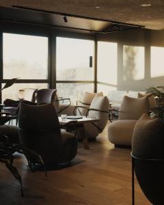 a waiting room with chairs and tables and windows at Hotel Belvedere - Fine Dining, Hideaway & SPA in San Genesio Atesino