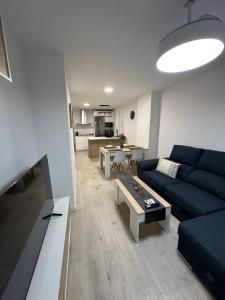 a living room with a blue couch and a table at Koala21 - Apartamento céntrico y moderno con Parking in Jaén
