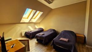 two beds in a room with two windows at Hotelik MOSiR Reda in Reda