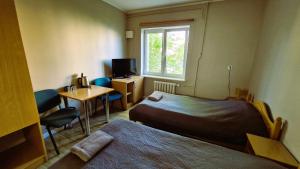 a room with two beds and a desk and a window at Hotelik MOSiR Reda in Reda +25 photos