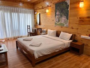 a bedroom with a large bed in a wooden room at Shaan Coco Palms Beach Resort in Morjim +77 photos