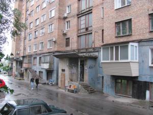 dos personas caminando por una calle frente a los edificios en Apartment on Sobornyi Avenue en Zaporiyia