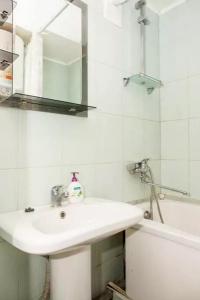 La salle de bains est pourvue d'un lavabo, d'un miroir et d'une baignoire. dans l'établissement Apartment on Sobornyi Avenue, à Zaporijia