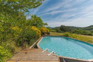 a swimming pool with a wooden ramp and a wooden deck at Ma Maison De Loin - Luberon in Apt