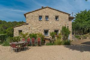 a stone house with a table and chairs in front of it at Ma Maison De Loin - Luberon in Apt
