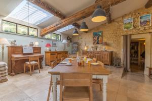 a large dining room with a table and a kitchen at Ma Maison De Loin - Luberon in Apt