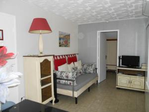 a living room with a couch and a red lamp at Herault Maraussan in Maraussan