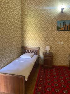 a bedroom with a bed and a red carpet at TURKMAN's PALACE in Urganch +15 photos