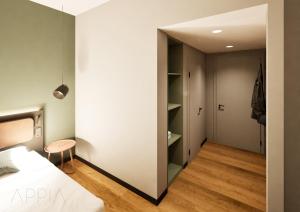 a bedroom with a bed and a closet at Essential by Dorint Mannheim Taylor Park in Mannheim