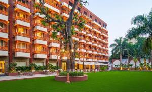 a hotel with a green lawn in front of a building at Bhagirathi By Atishay in Haridwār