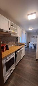a kitchen with white cabinets and a wooden counter top at Dunavirág Vendégház in Pilismarót