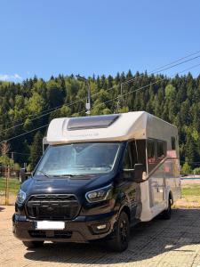 a black and white truck driving down a road at Kamper Park Babia Góra - parcele kamperowe in Zawoja +44 photos