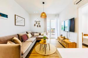 a living room with a couch and a table at Boho Mar Drymadhes by PS in Dhërmi