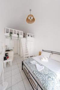 a white bedroom with a bed and a desk at ALMA THERA Boutique Hotel in Perissa