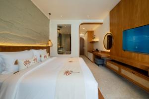 a bedroom with a large bed and a flat screen tv at Lomo Boutique Hotel & Villas, Uluwatu in Uluwatu +125 photos