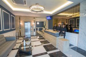 a lobby with three people sitting at a counter at Redpine Hotel in Skudai
