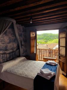 a bedroom with a bed and a large window at La Posada de San Martin in San Martín del Castañar