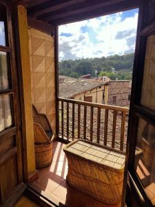 a balcony with two chairs and a large window at La Posada de San Martin in San Martín del Castañar