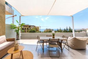 a patio with a table and chairs on a balcony at Boho Mar Drymadhes by PS in Dhërmi