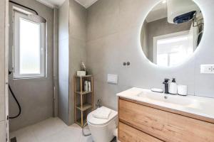 a bathroom with a sink and a toilet and a mirror at Boho Mar Drymadhes by PS in Dhërmi +13 photos
