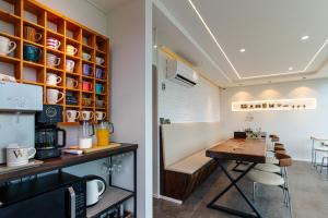 a kitchen with a wooden table and a counter with chairs at 한옥스테이 화랑루 in Gyeongju