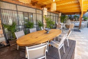 a wooden table and chairs on a patio at וילה ואמוס - Villa vamos - וילה מדהימה עם בריכה פרטית וג'קוזי in Rosh Pinna
