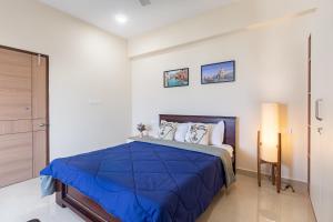 a bedroom with a bed with a blue comforter at Altura in Bangalore