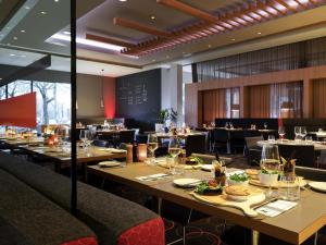 a dining room with tables and chairs in a restaurant at Novotel Amsterdam City in Amsterdam