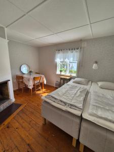 a bedroom with a large bed and a table at Rolfskärrs Stugby in Nygård +83 photos