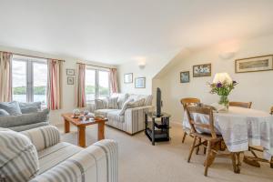 a living room with couches and a table and a tv at 3 Bed in Polruan oc-pc049 in Fowey +22 photos