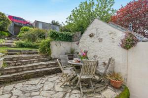 a patio with a table and chairs and stairs at 3 Bed in Polruan oc-pc049 in Fowey
