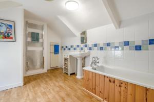 a bathroom with a sink and a bath tub at 3 Bed in Polruan oc-pc049 in Fowey