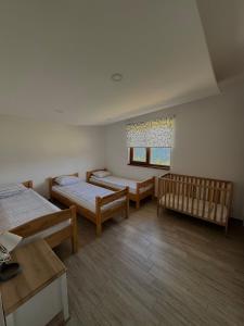 a room with two beds and two cribs in it at Vlasic Odmor - Villa Wellnes & spa in Vlasic +77 photos