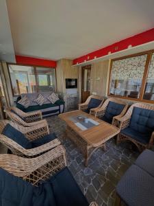 a living room with wicker chairs and a table at Vlasic Odmor - Villa Wellnes & spa in Vlasic