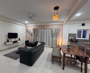 a living room with a black leather couch and a table at Altura in Bangalore