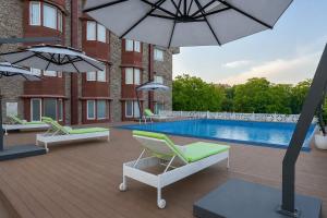 a patio with chairs and a pool in front of a building at Bhagirathi By Atishay in Haridwār