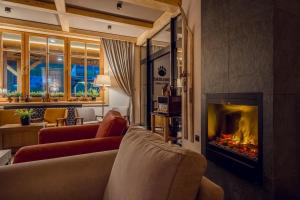 a living room with a fireplace and a couch at Kamper Park Babia Góra - parcele kamperowe in Zawoja