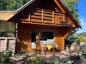 a cabin with a table and chairs in front of it at Gemütliches Blockhaus in Harsefeld +9 photos