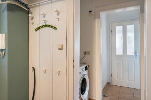 a laundry room with a washer and dryer at Park – House in Oldenburg in Holstein