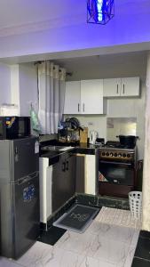 a kitchen with a stove and a refrigerator at Infinite Stays in Thika