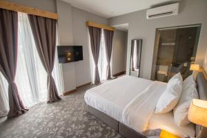 a hotel room with a large bed and windows at Redpine Hotel in Skudai +9 photos