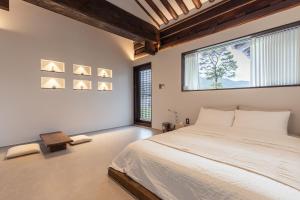 a bedroom with a large bed and a large window at 한옥스테이 화랑루 in Gyeongju
