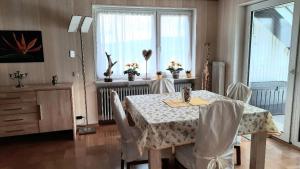 a dining room with a table and chairs and a window at Ferienwohnung Klosterblick in Homburg +7 photos