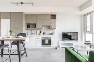 a kitchen with white cabinets and a table and chairs at Atlantis Suites The Entertainment District - Toronto in Toronto +43 photos